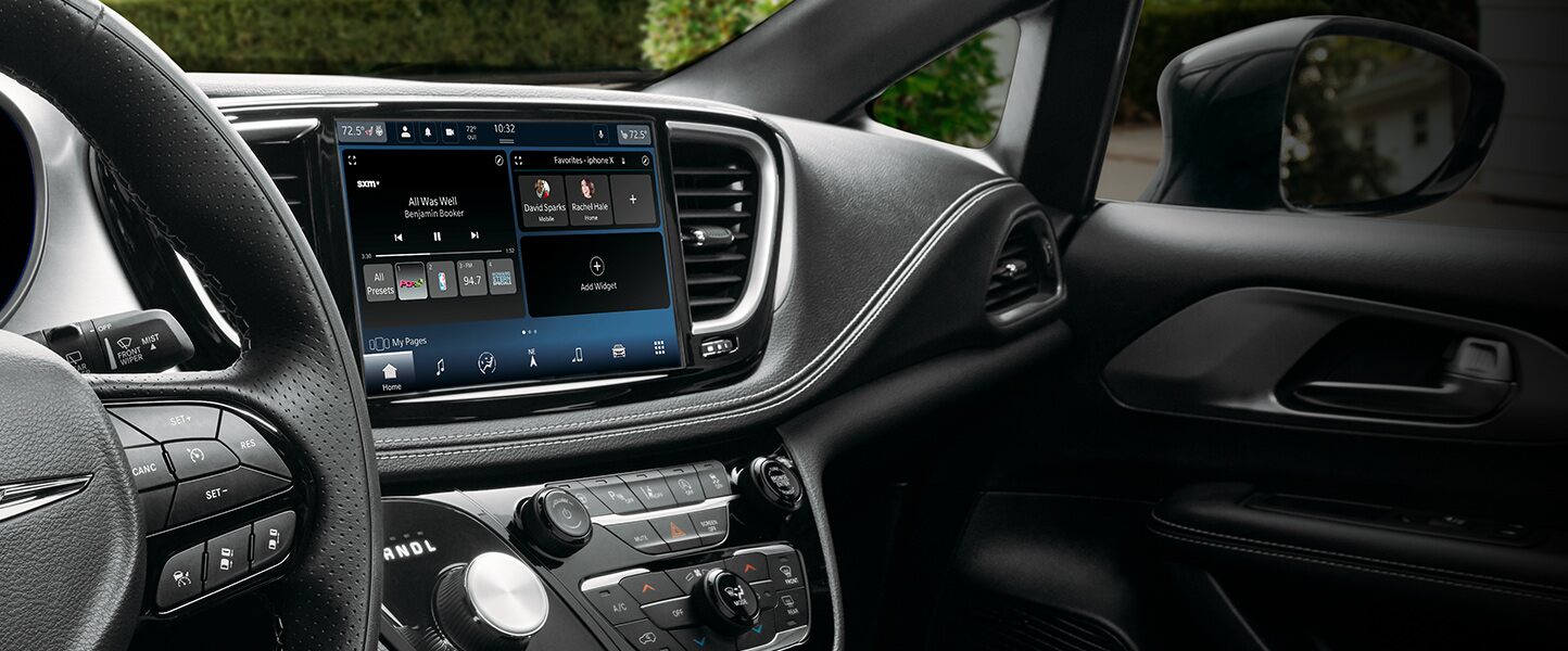 Primer plano de la pantalla táctil del sistema Uconnect en la Chrysler Pacifica 2023, en la que se muestran selecciones de SiriusXM.