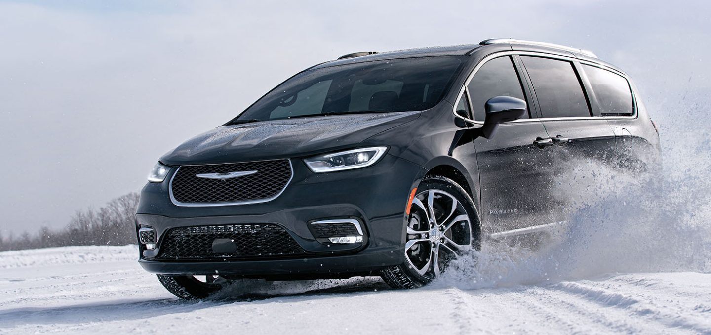 Mostrar Una Chrysler Pacifica Pinnacle 2024 andando sobre una superficie cubierta de nieve.