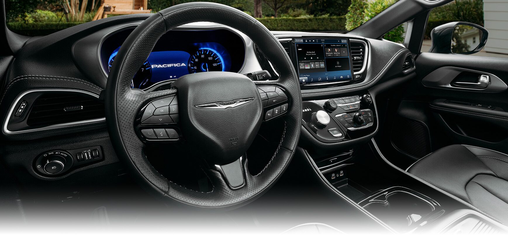 El volante, la pantalla digital de información para el conductor, la pantalla táctil Uconnect y los controles de la consola central en la Chrysler Pacifica Plug-In Hybrid 2024.