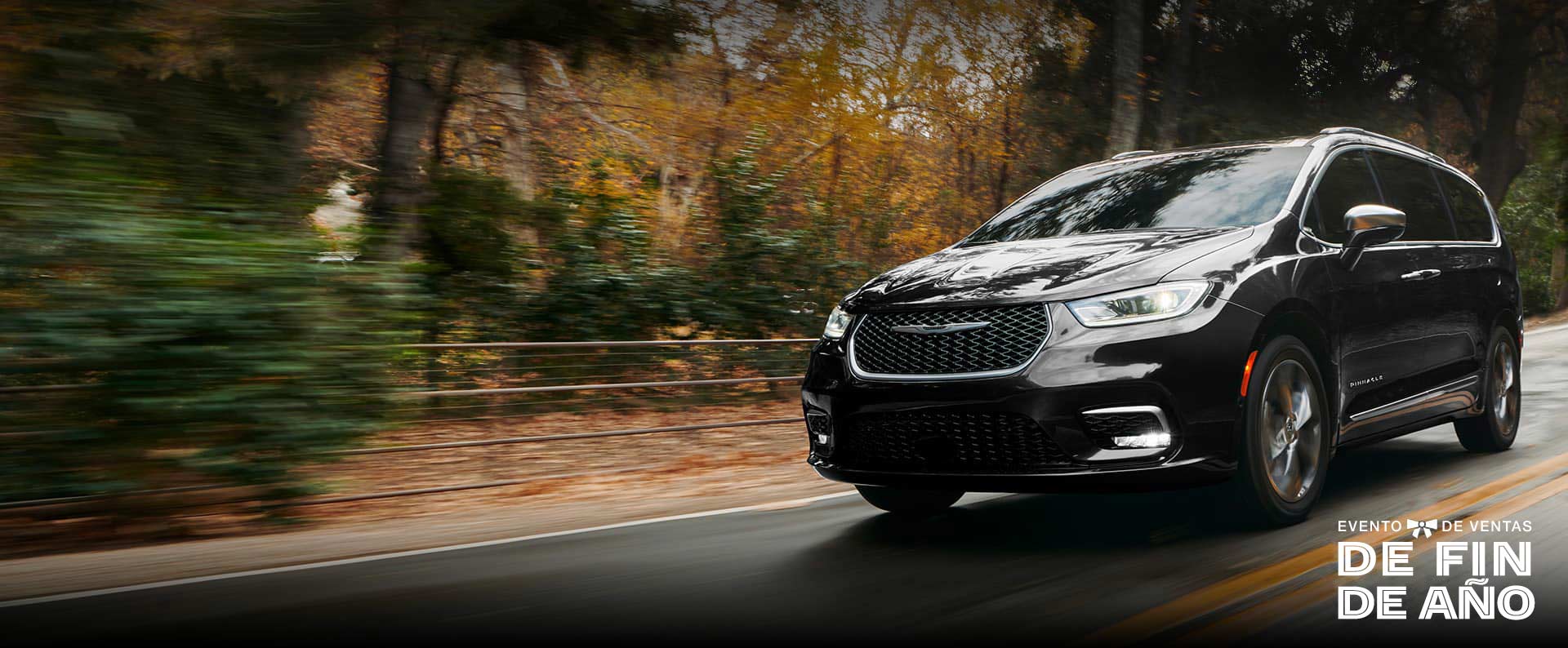 Perfil desde el ángulo del conductor de la Chrysler Pacifica Pinnacle 2024 circulando por un camino campestre; el fondo está borroso para indicar que el vehículo está en movimiento. Evento de ventas Fin de año.