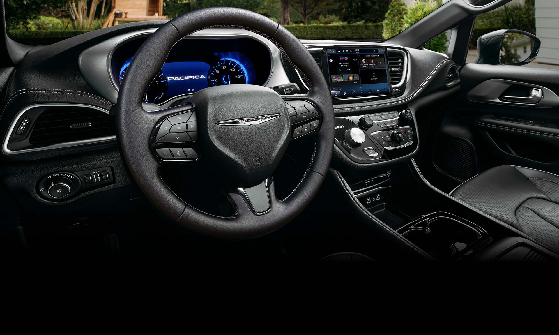 El volante, la pantalla del tablero de instrumentos digital y la pantalla táctil Uconnect en la Chrysler Pacifica Hybrid 2025 enchufable.