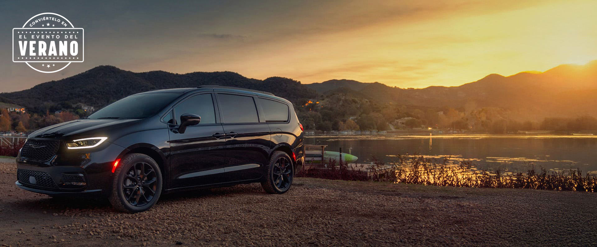 Una Chrysler Pacifica Limited 2025 negra estacionada al lado de un lago, al atardecer. Evento de ventas Precios de empleado. Conviértelo en el evento de ventas del verano​​​​​​​.