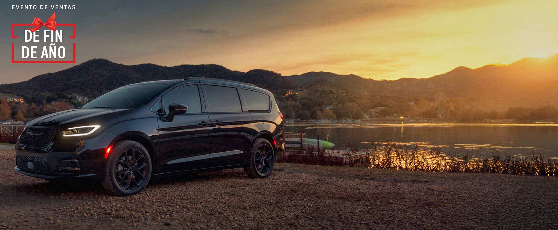 Una Chrysler Pacifica Limited 2025 negra estacionada al lado de un lago, al atardecer. Evento de ventas Precios de empleado. Evento de ventas Fin de año.