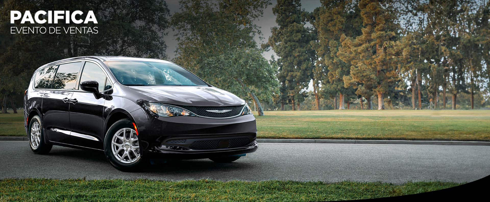 Vista lateral del lado del acompañante de un Chrysler Voyager LX 2025 negro en el estacionamiento de un parque. Evento de ventas de Chrysler Pacifica.