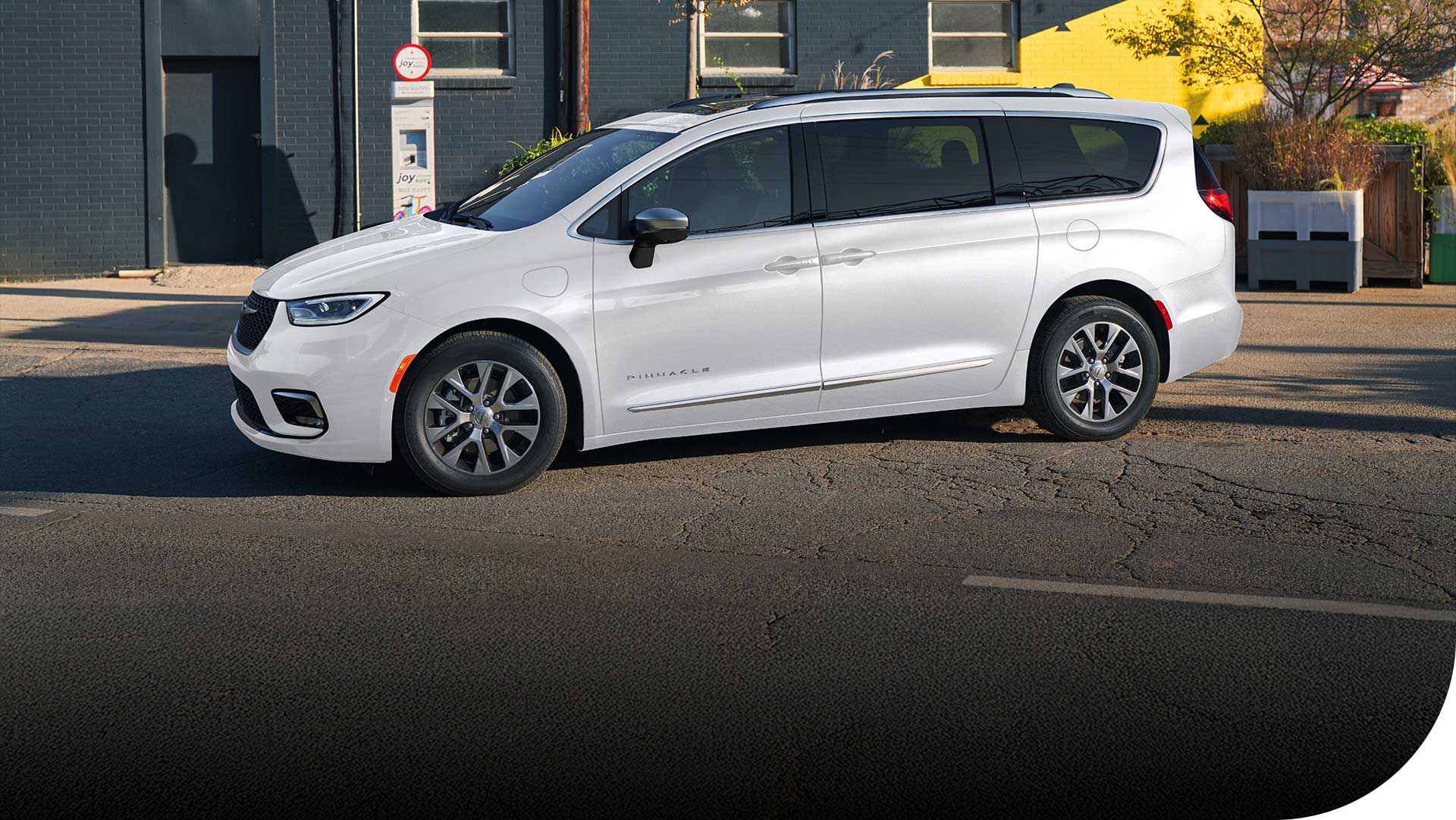 Perfil del lado del conductor de una Chrysler Pacifica Plug-in Hybrid Pinnacle 2026 de color blanco.
