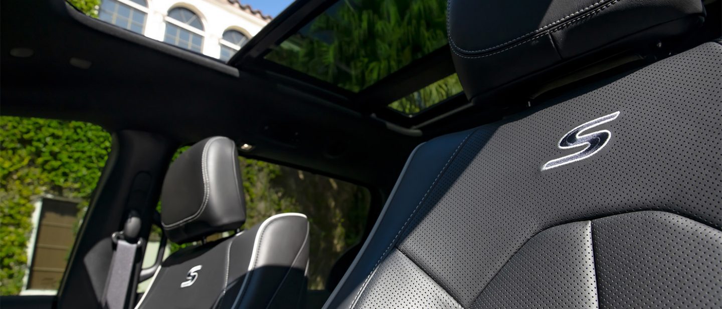 Se muestran los asientos delanteros con la letra "S" bordada, justo debajo de los apoyacabezas, en la Chrysler Pacifica Plug-in Hybrid Select 2026 con el paquete de apariencia Premium S.