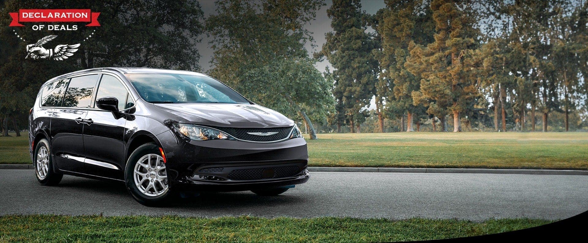 Vista frontal del lado del pasajero del Chrysler Voyager LX 2026 en el estacionamiento de un parque. Evento de ventas Declaración de ofertas.