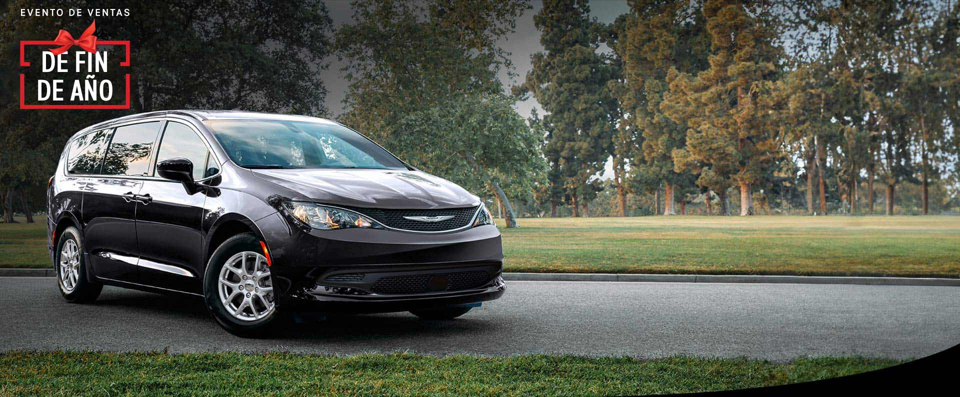 Vista frontal del lado del pasajero del Chrysler Voyager LX 2025 en el estacionamiento de un parque. Evento de ventas Fin de año.