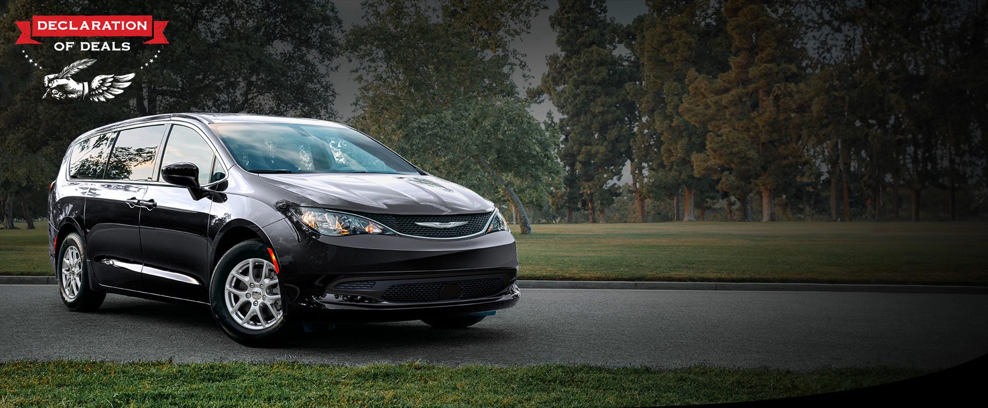 Vista frontal del lado del pasajero del Chrysler Voyager LX 2026 en el estacionamiento de un parque. Evento de ventas Declaración de ofertas.