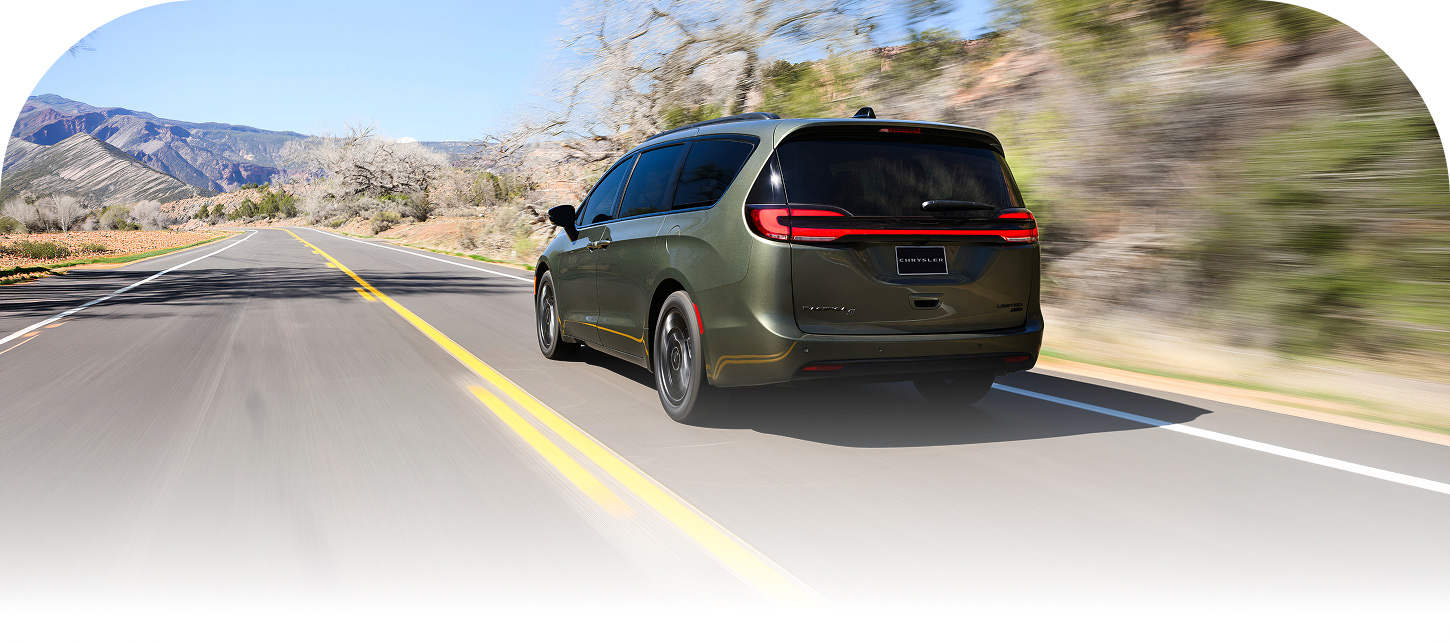 La parte trasera de una Chrysler Pacifica Limited 2027 en Olive Green con el paquete de apariencia S, circulando por una autopista.
