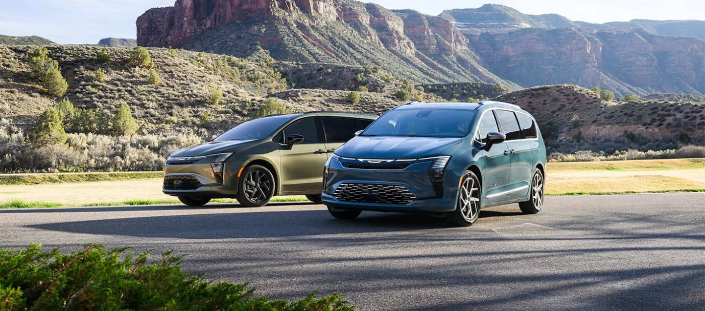 Muestra dos minivans Chrysler Pacifica 2027 estacionadas una frente a la otra: a la izquierda, una Pacifica Limited en Olive Green con el paquete de apariencia S, y a la derecha, una Pacifica Pinnacle en color azul.