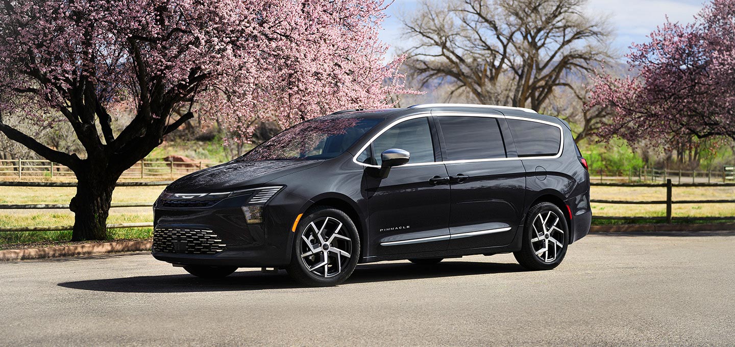 Una Chrysler Pacifica Pinnacle 2027 negra en un parque.