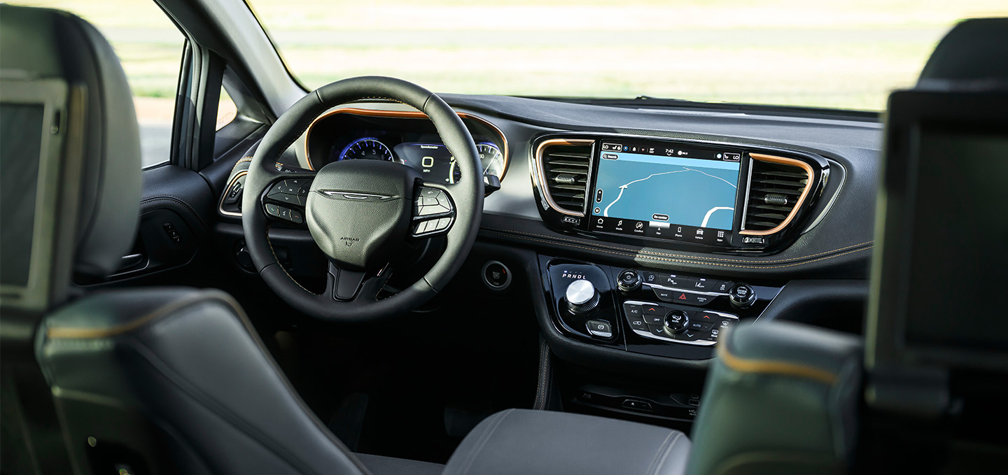 Instrumentos en la Chrysler Pacifica 2027, incluidos el volante, la pantalla digital del panel de instrumentos, la pantalla táctil Uconnect y los controles de la consola central.