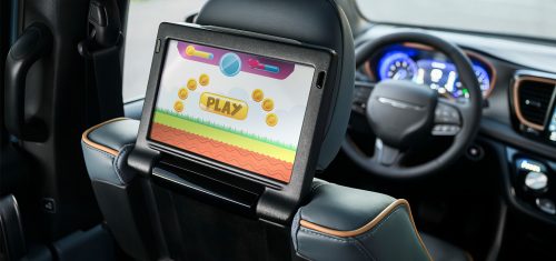 La Chrysler Pacifica Pinnacle 2027 centrándose en la pantalla táctil situada en el respaldo del asiento del conductor, para los pasajeros de la segunda fila.